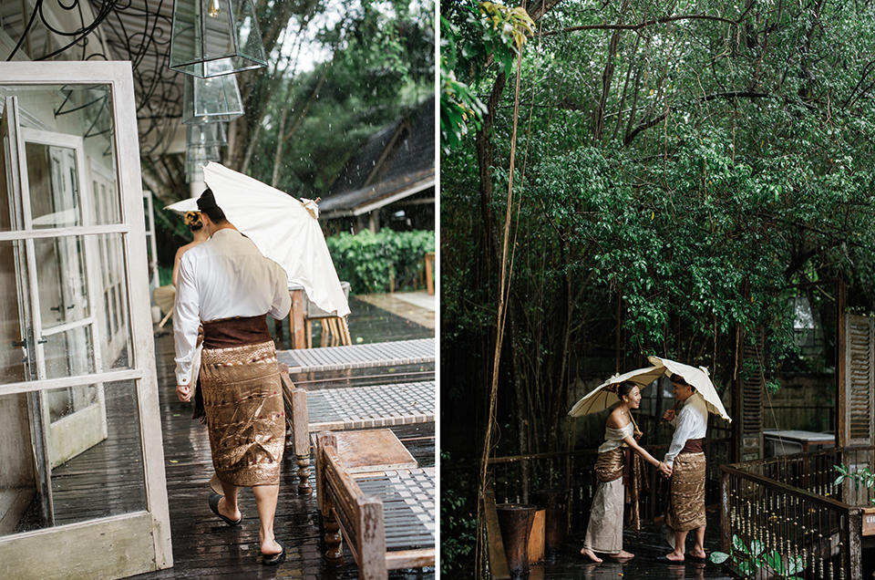 Bali couple photoshoot at Balquisse Heritage Hotel with couple in traditional Balinese outfit under umbrellas in a lush tropical rain setting