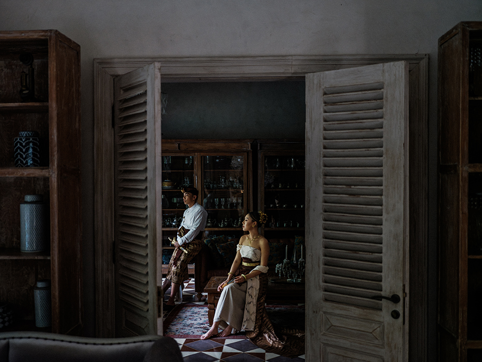 Bali couple photoshoot at Balquisse Heritage Hotel featuring couple in traditional Balinese outfit inside an intimate vintage interior