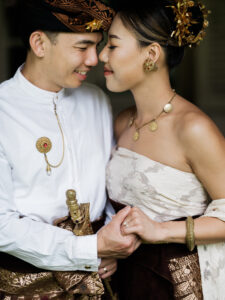 Intimate close-up of bride and groom wearing traditional Balinese-inspired outfits at Balquisse Heritage Hotel Jimbaran Bali, highlighting cultural wedding details.