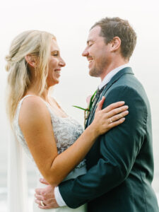 Intimate moment of bride and groom smiling and holding each other at Wonderland Uluwatu Bali, capturing genuine wedding emotions.