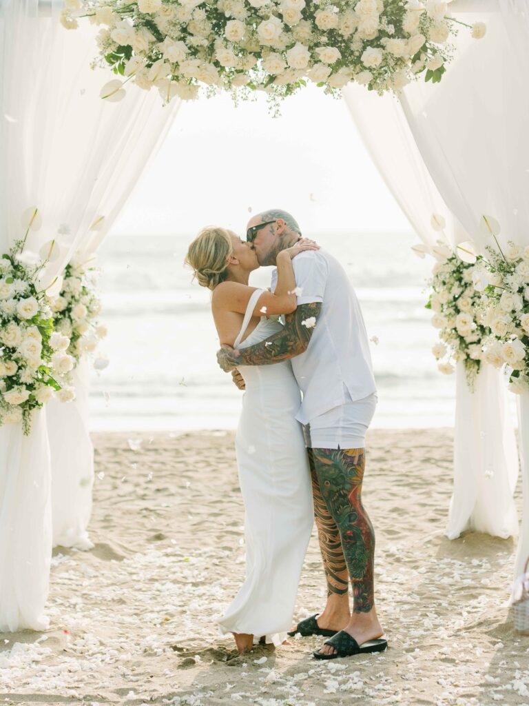 bali elopement wedding beach ceremony couple kiss floral arch intimate documentary photography