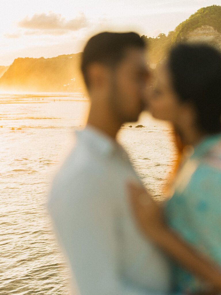 Pre-wedding photoshoot Bali Uluwatu golden hour couple kissing beach