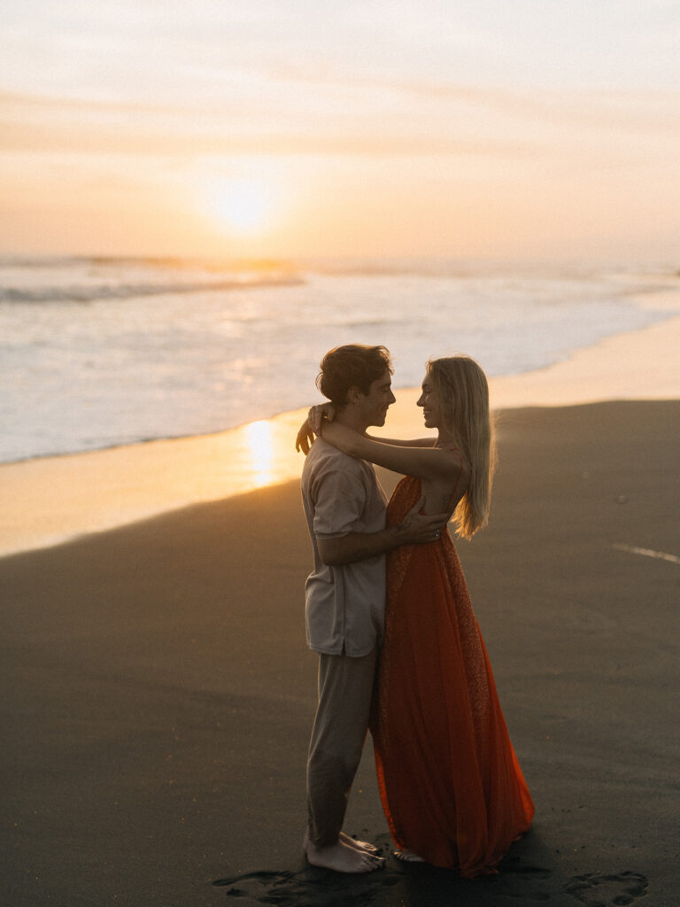 Canggu couple photoshoot Bali sunset black sand beach orange dress