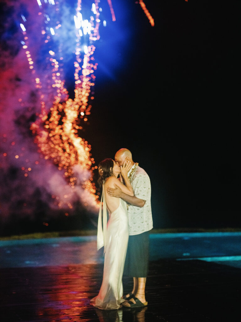 Couple kissing with fireworks at Villa Vedas Bali wedding — luxury documentary wedding photography in Bali
