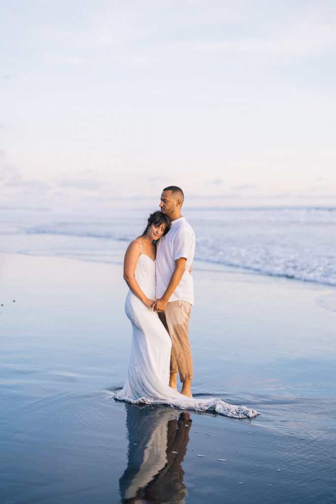 Pre-wedding photoshoot Bali beach sunrise reflection white dress