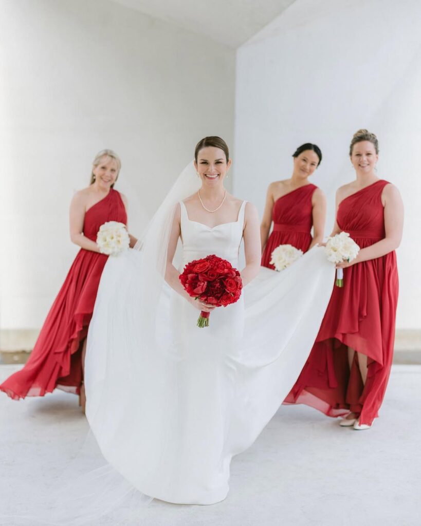 Bride with bridesmaids in red dresses — consistent editing style across bridal party portrait, Vancouver wedding photographer