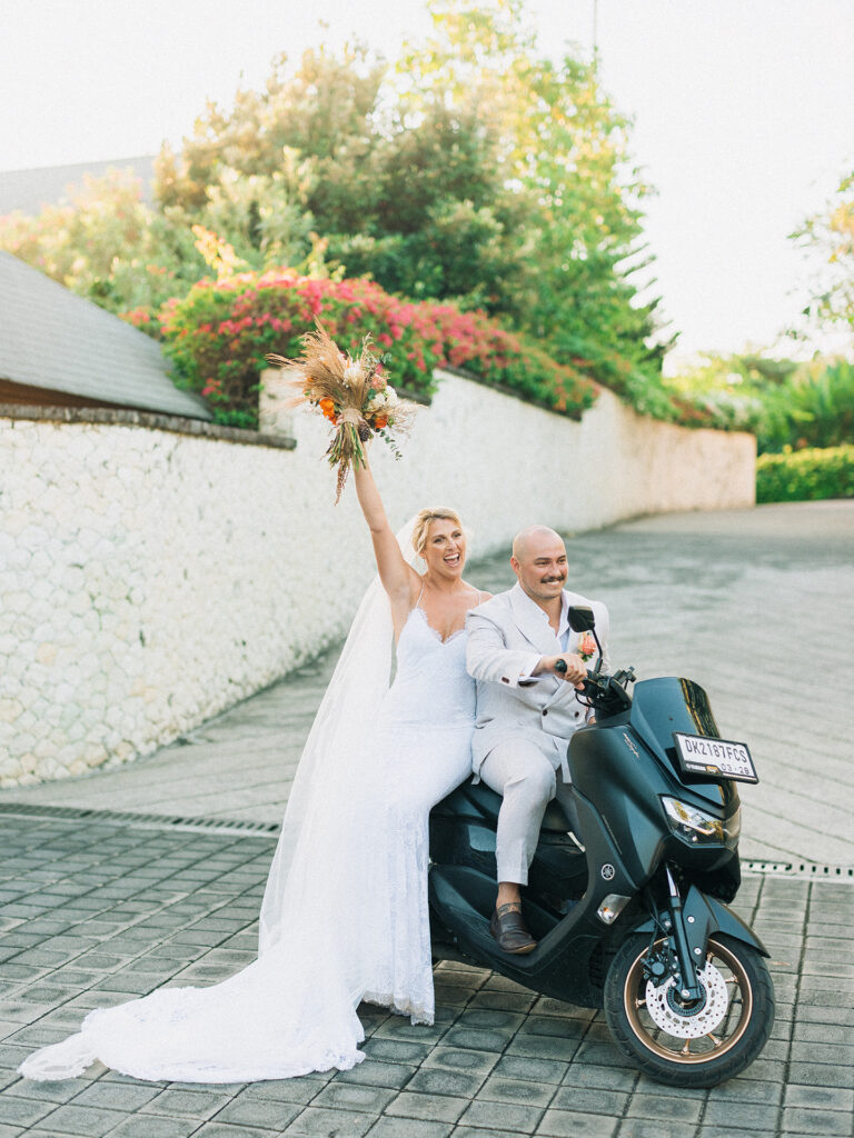 Aimee and Blake riding a scooter during their Bali wedding experience in a fun and candid moment