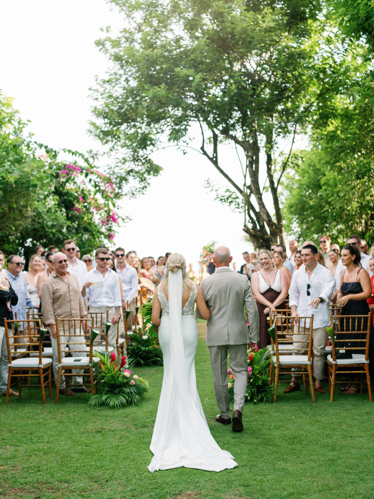 Wonderland Uluwatu wedding ceremony bride walking down the aisle with her father in Bali