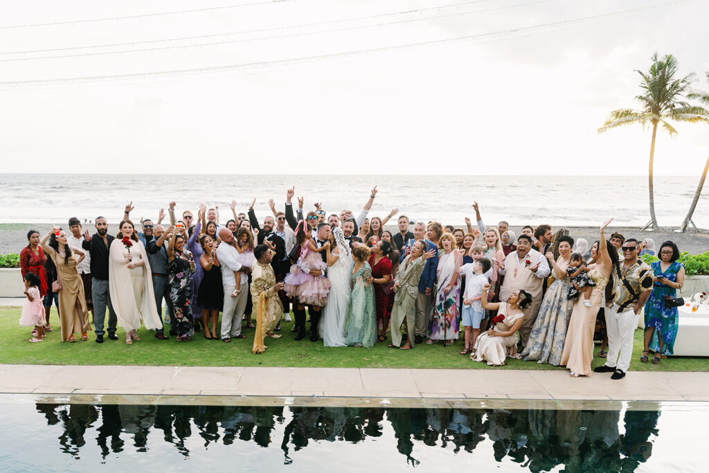 Large group family photo at Bali beachfront wedding — efficient and energetic, captured by documentary wedding photographer Bali