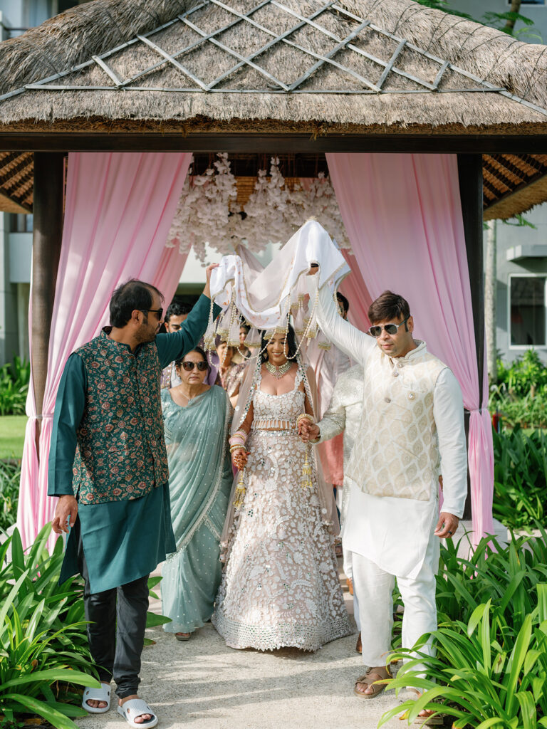 indian wedding bali bride entrance ceremony with family under canopy at conrad bali