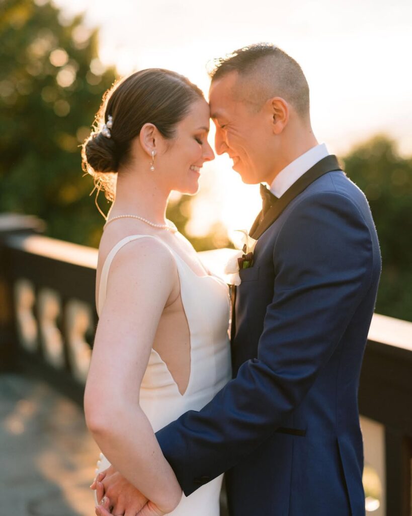 Amanda and Tony golden hour portrait on Cecil Green Park House terrace, foreheads touching at sunset