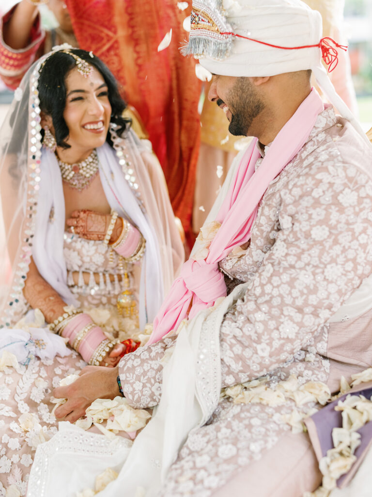 Indian bride and groom sharing a genuine laugh during Bali wedding ceremony — unposed moment captured by documentary photographer