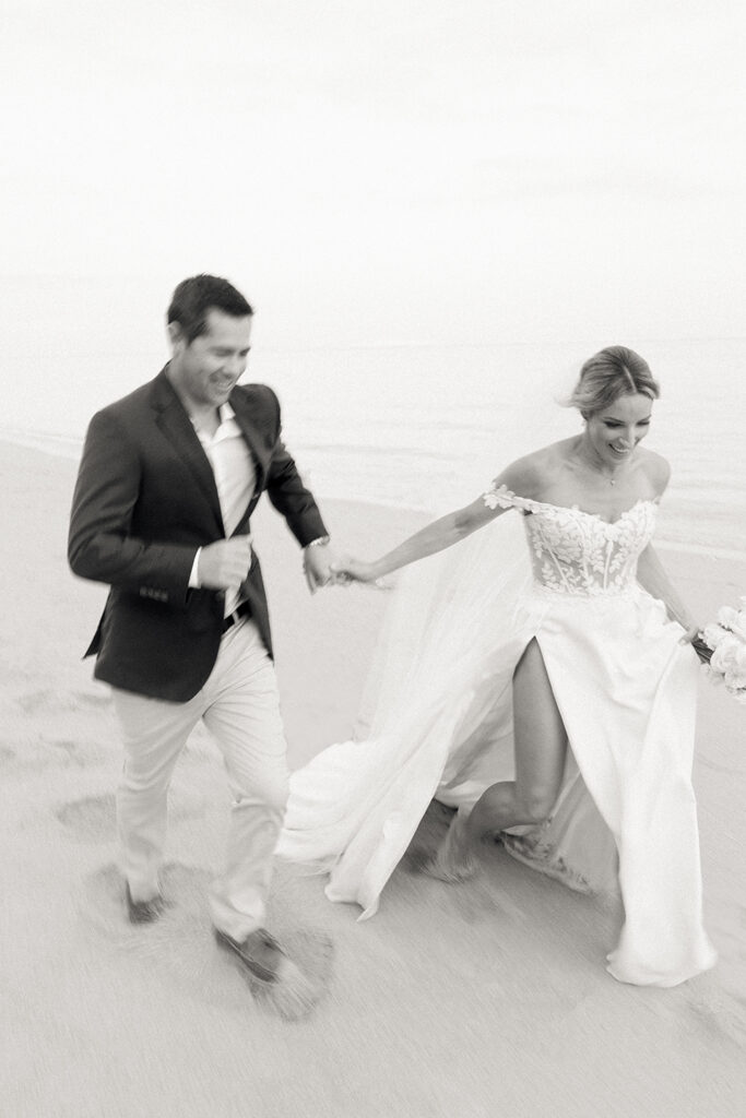 Bride and groom running on Bali beach — candid movement and joy captured by documentary wedding photographer