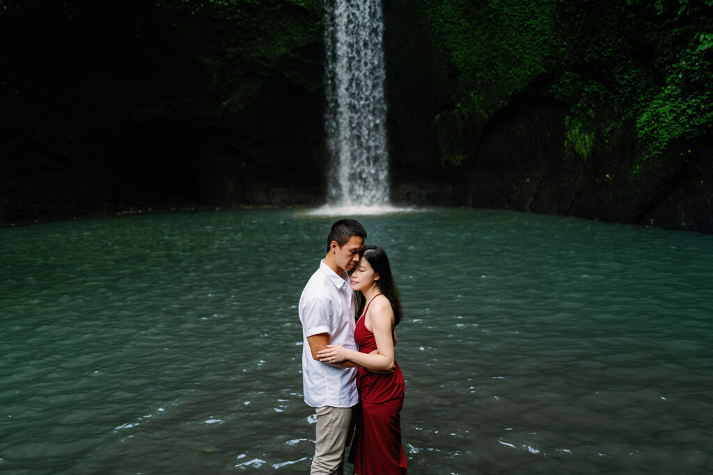 Pre-wedding photoshoot Bali Tibumana waterfall red dress natural light