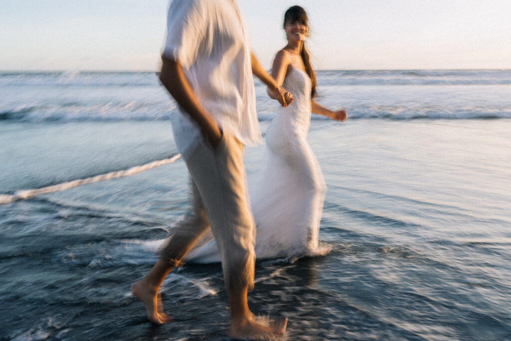 intimate couple session bali sofian ilsey playful walking in ocean motion blur at pasut beach
