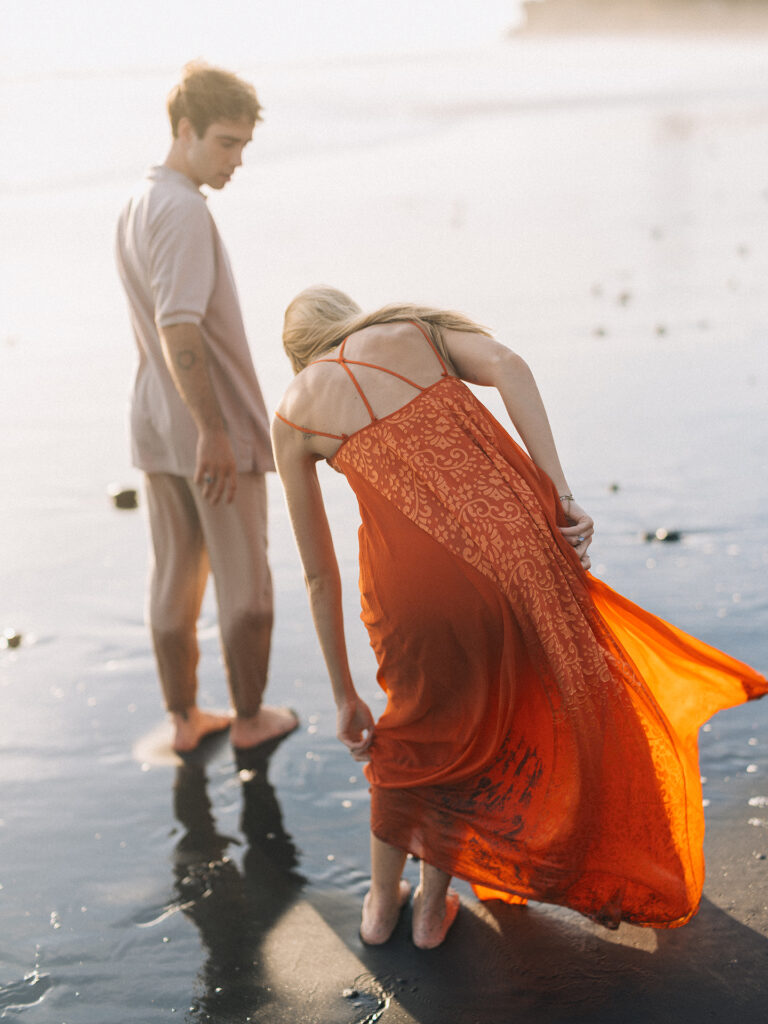 romantic couple session bali kira conor candid moment with flowing dress at nyanyi beach