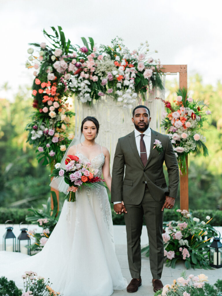 Ubud elopement ceremony at Jannata Resort Bali with bride and groom under floral arch