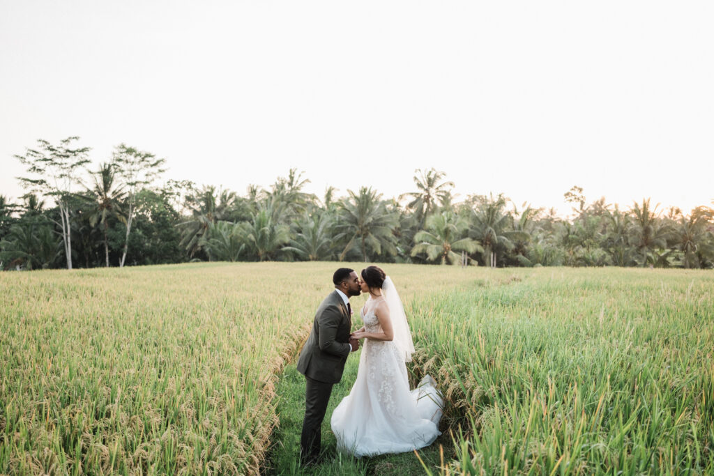 Ubud elopement couple kissing in rice field Bali during intimate wedding session