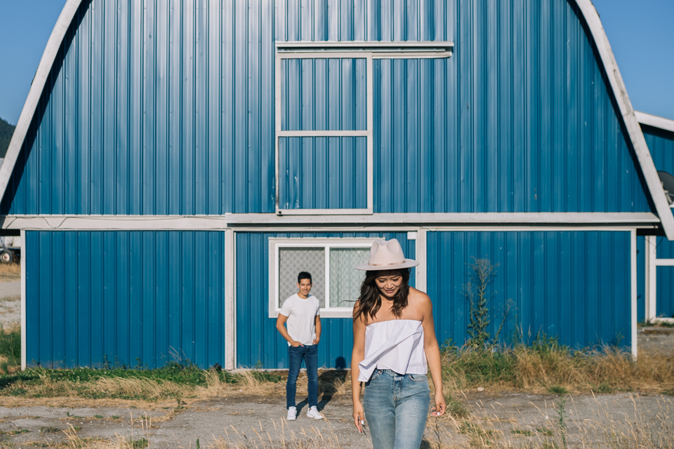 Winnie walking in front of blue barn, Dave in background — Vancouver BC