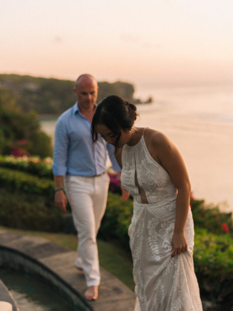 Uluwatu sunset wedding Bali couple walking by the cliff with ocean view during golden hour portrait session