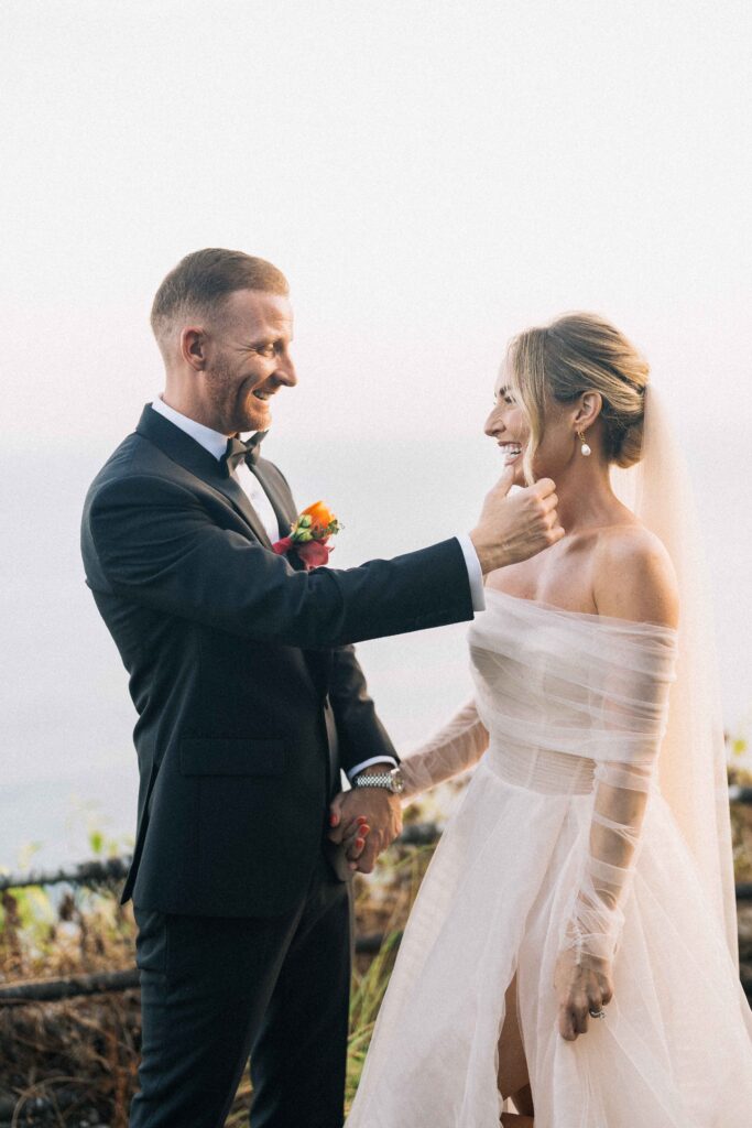 tirtha uluwatu wedding couple portrait bali bride and groom smiling ocean cliff sunset