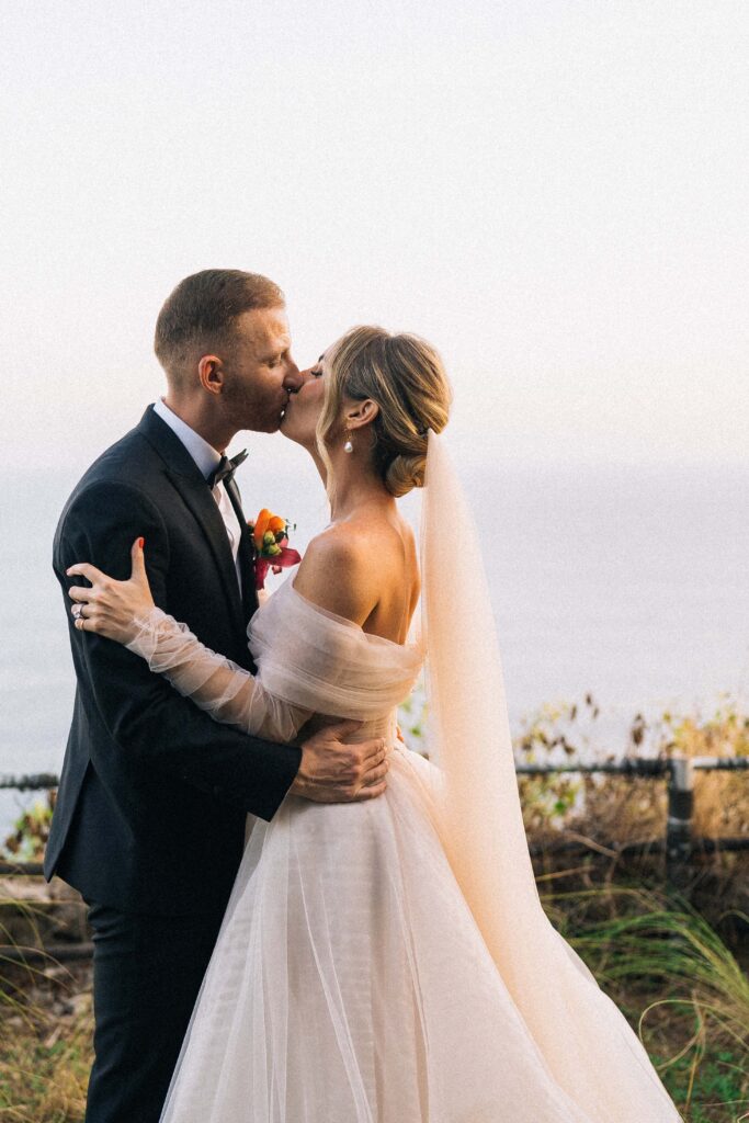 best time to get married in bali golden hour couple kiss ocean cliff uluwatu documentary wedding photography dry season