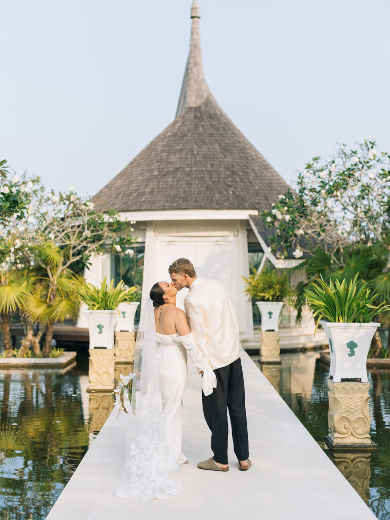 couple standing at Puri Temple Hill wedding venue chapel entrance with lotus pond in Jimbaran Bali