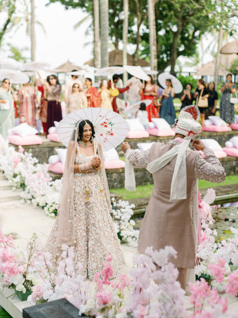 indian wedding bali outdoor ceremony couple entrance at conrad bali with floral decoration