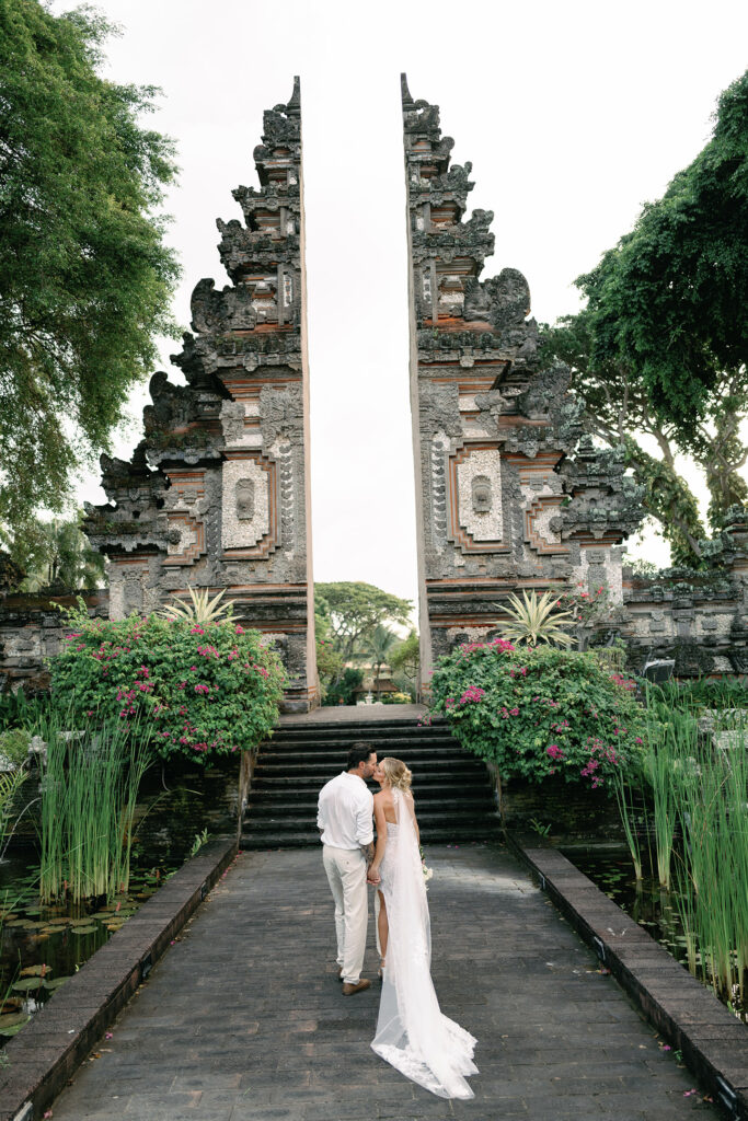 Couple at a traditional Balinese temple gate during their wedding portrait session in Bali
