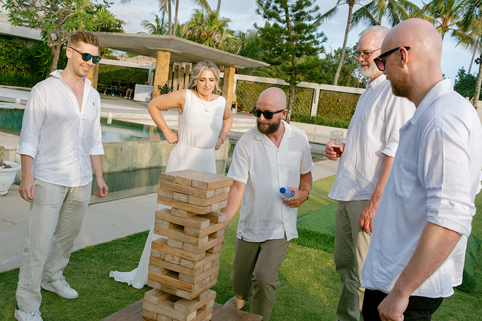 Wedding guests playing giant Jenga by the pool during a relaxed sunset celebration at Villa Vedas Bali.