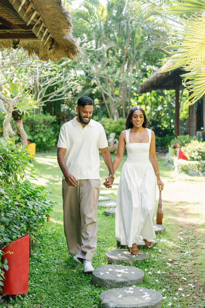 Indian couple walking hand in hand through the tropical garden before a surprise proposal in Bali