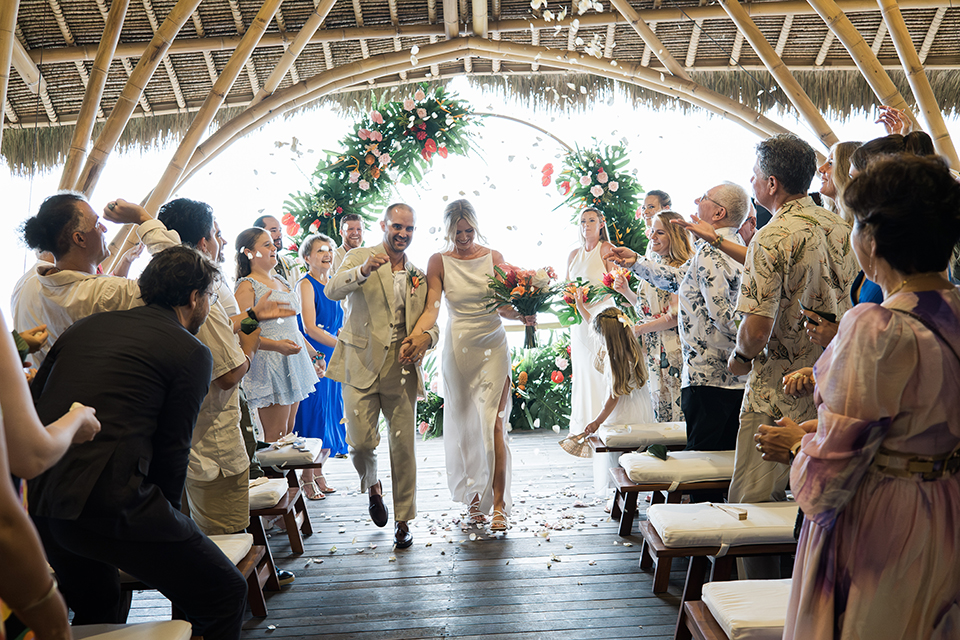 Wedding recessional at Komune Resort Bali bamboo pavilion with confetti and guests celebrating