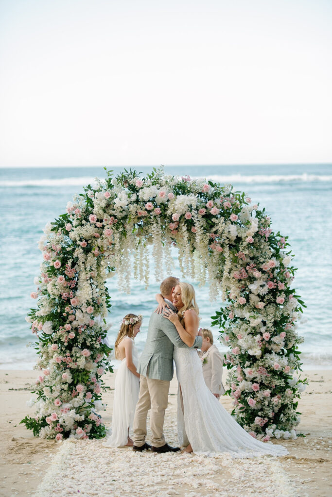 Kaylene and Ben family elopement at Melasti Beach Bali — floral arch ceremony with children — Luxima Wedding