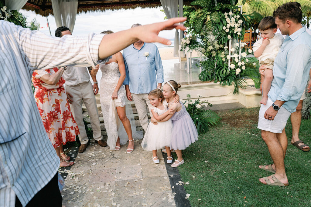 Ceremony — Candid kids moment after ceremony Alt text: Candid moment with flower girls after wedding ceremony at Nusa Dua Beach Hotel Bali — natural wedding photography by Luxima Wedding