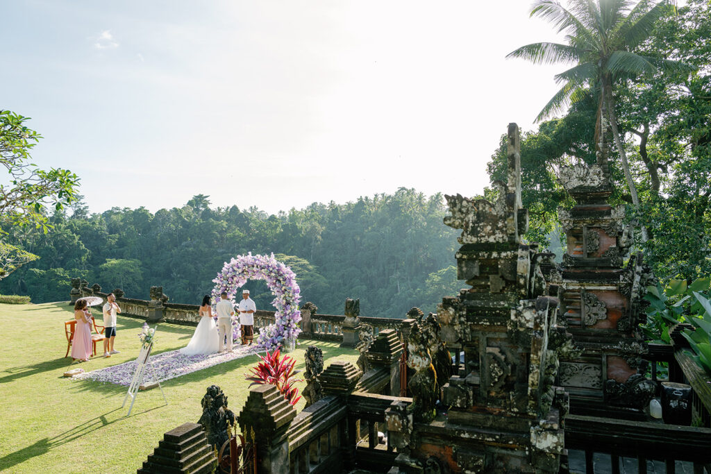 Intimate elopement ceremony at Puri Wulandari Ubud with purple floral arch and Ayung River valley backdrop — Luxima Wedding photography