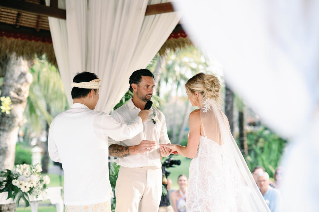 Ceremony — Ring exchange Alt text: Ring exchange during wedding ceremony at Nusa Dua Beach Hotel Gazebo Bali — documentary Bali wedding photography by Luxima Wedding