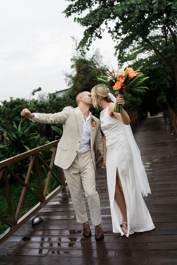 Couple celebrating in the rain after wedding ceremony at Komune Resort Keramas Beach Bali