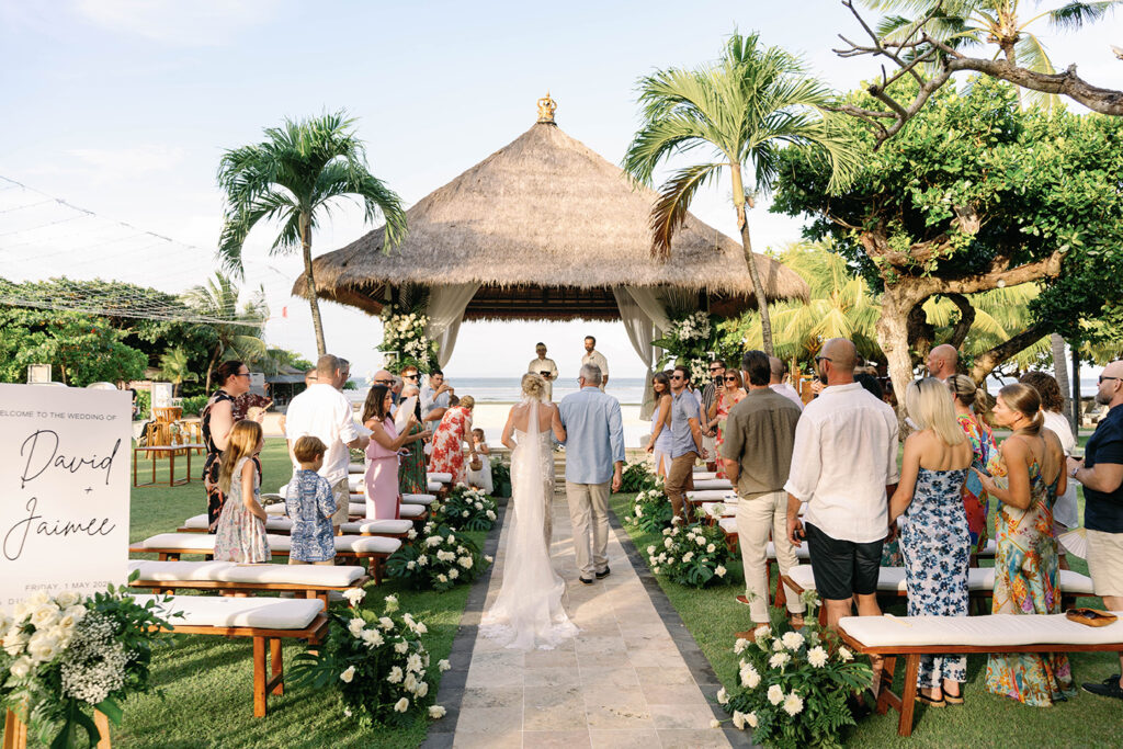 Wide shot aisle + Gazebo Alt text: Wedding ceremony at Nusa Dua Beach Hotel Gazebo Bali with bride walking down aisle — Luxima Wedding documentary photographer