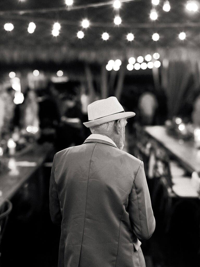 Documentary wedding photography Komune Resort Bali — guest at reception under string lights