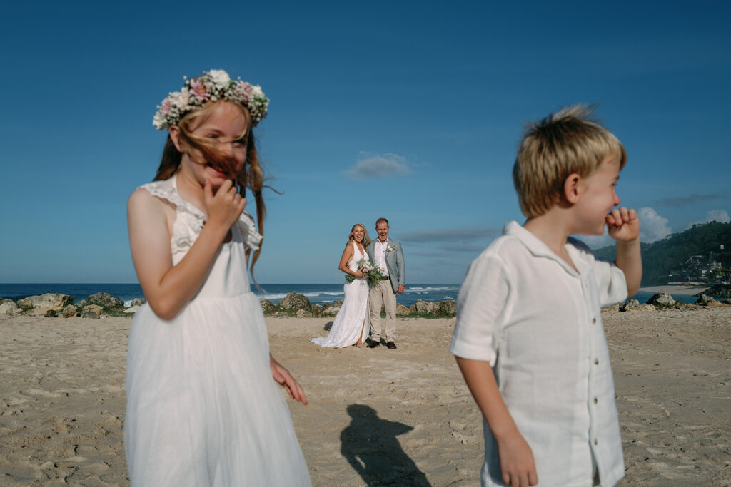 Children laughing during family elopement at Melasti Beach Bali — candid wedding photography