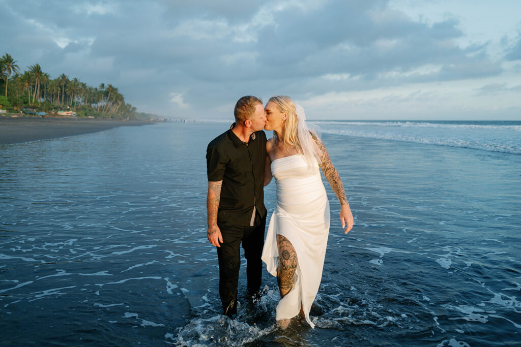 Kaytie and Jamie kissing at Pasut Beach during their vow renewal in Bali — Luxima Wedding
