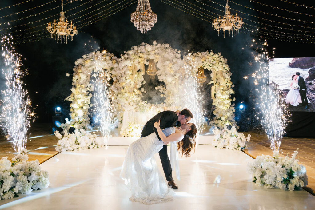 First dance dip kiss with cold fireworks and gold chandeliers at Villa Plenilunio Uluwatu wedding reception — Luxima Wedding