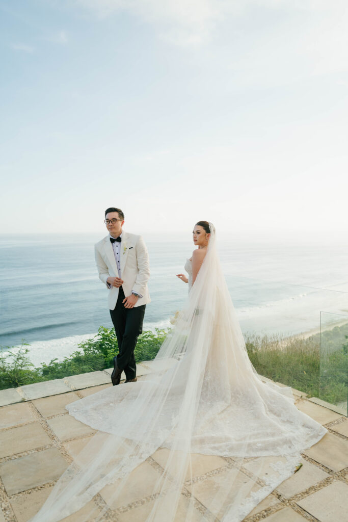 Bride and groom standing on Villa Plenilunio Uluwatu clifftop terrace overlooking Nunggalan Beach and Indian Ocean — Luxima Wedding