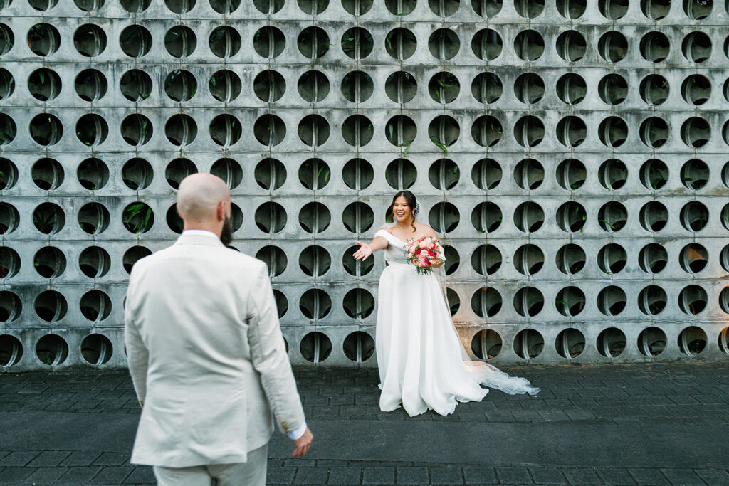 Janela laughing as Jack walks towards her at Peppers Seminyak perforated wall Bali wedding