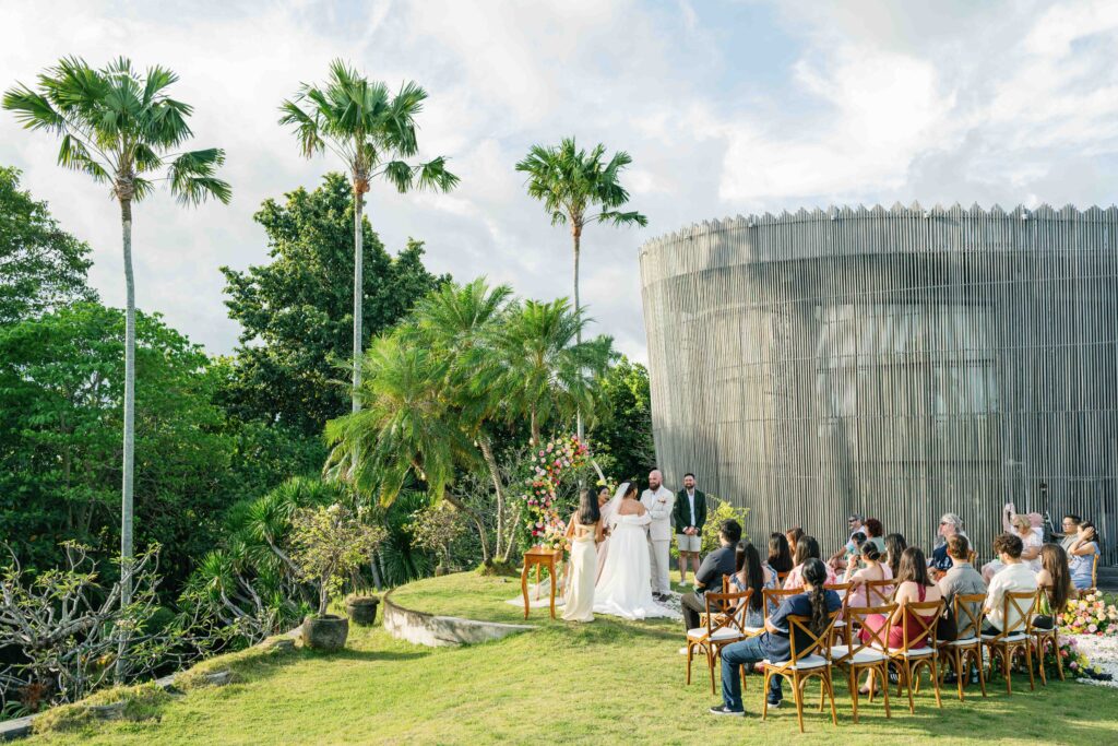 Outdoor wedding ceremony at Peppers Seminyak Bali with guests seated on garden lawn