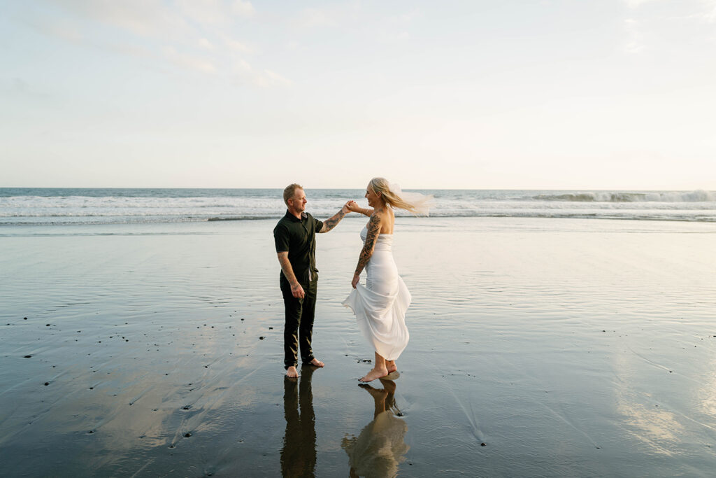 Couple dancing at low tide on Pasut Beach Bali vow renewal session at sunset — Luxima Wedding