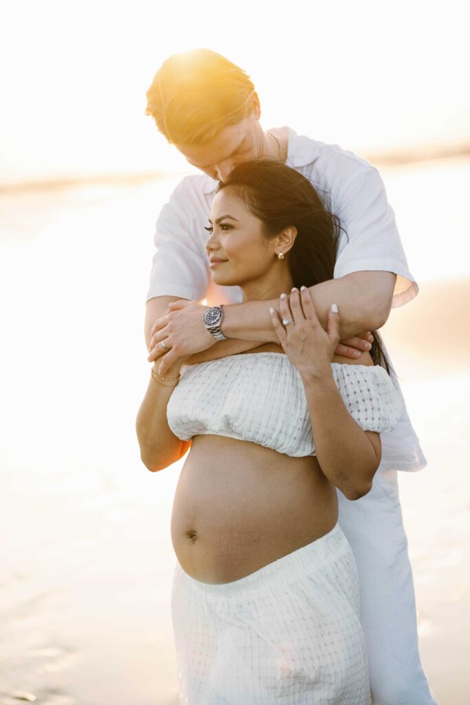 Tom embracing Elly at golden hour Nyanyi Beach Bali maternity session