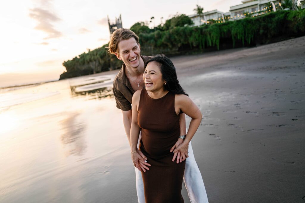 Elly and Tom laughing together Nyanyi Beach Bali maternity photoshoot